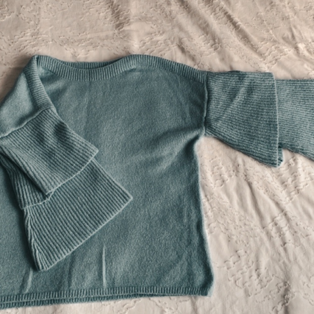 Women’s baby blue sweater with peplum sleeves.